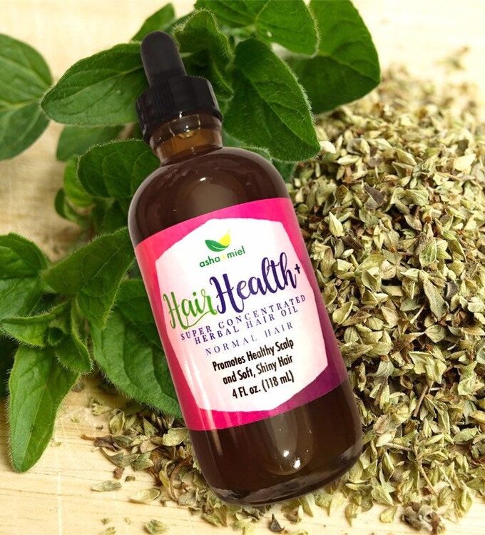 Super Concentrated Herbal Hair Oil, 4 oz glass dropper bottle on a background of herbs